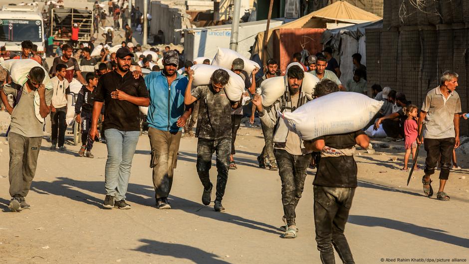 Gaza, Kan Junis - ljudi nose džakove sa brašnom nakon što je stigla humanitarna pomoć, 24. 07.2025.