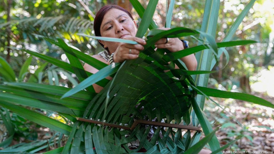 Mulher faz artesanato com folhas