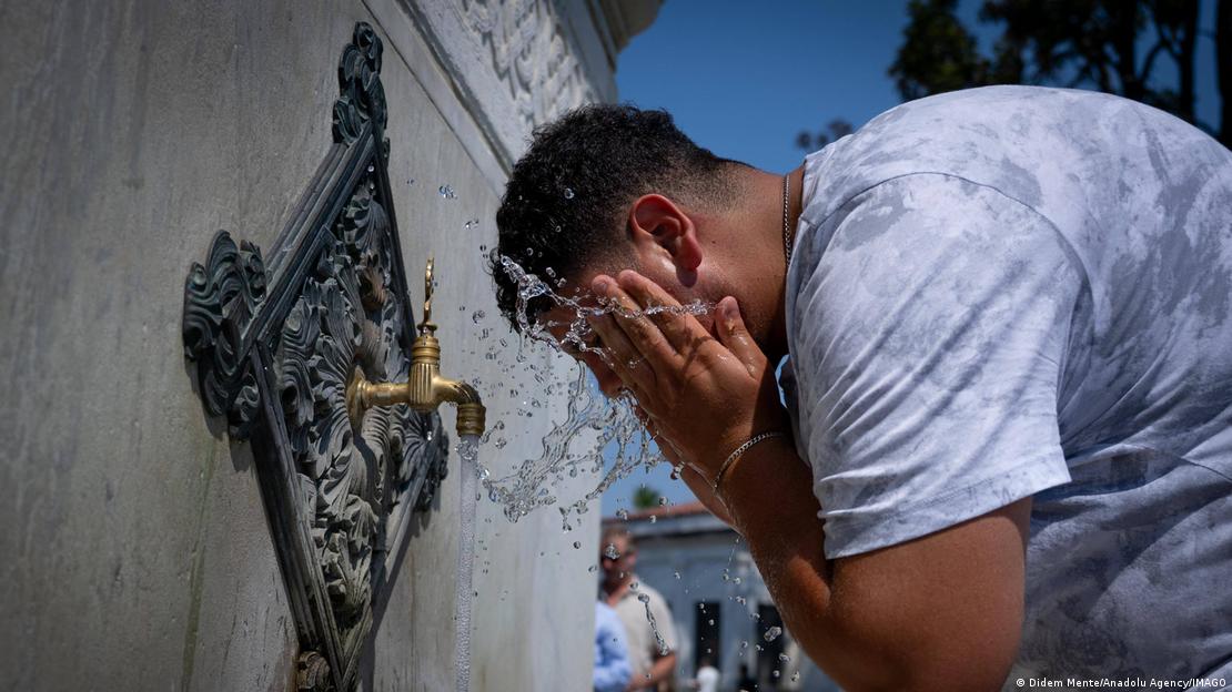 İstanbul'da bir vatandaş sokaktaki çeşme başında yüzünü yıkayarak serinlemeye çalışıyor