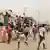 Moradores levam bens enquanto eclodem saques no distrito de Kalemba 2, em Luanda