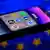 App icons of online platforms Google, Facebook, LinkedIn, Amazon, Apple Store and TikTok can be seen on the screen of a smartphone in front of an EU flag