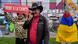 Hombre con sombrero. Detrás un hombre se cubre con bandera de Colombia. Una mujer lleva una pancarta: "Uribe a la cárcel". 