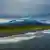 Arena oscura de origen volcánico da un matiz de rudeza al bello panorama en la campiña de Kamchatka.