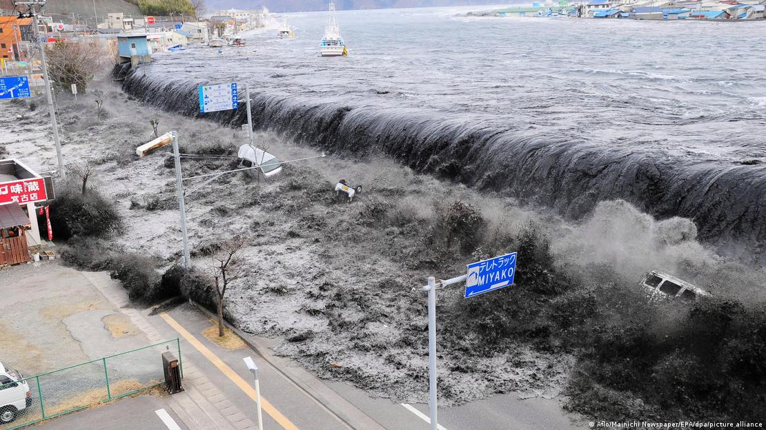 Onda gigantesca de tsunami invade avenida costeira e arrasta barcos e veículos em Fukushima em 2011