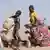 Dos Niños ayudan a preparar comida en un campamento de desplazados en El Fasher, el la región de Darfur del Norte, en Sudán, el 9 de julio de 2025.