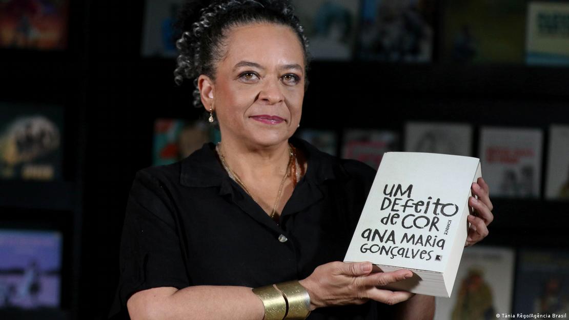 A escritora Ana Maria Gonçalves segura o seu livro Um defeito de cor