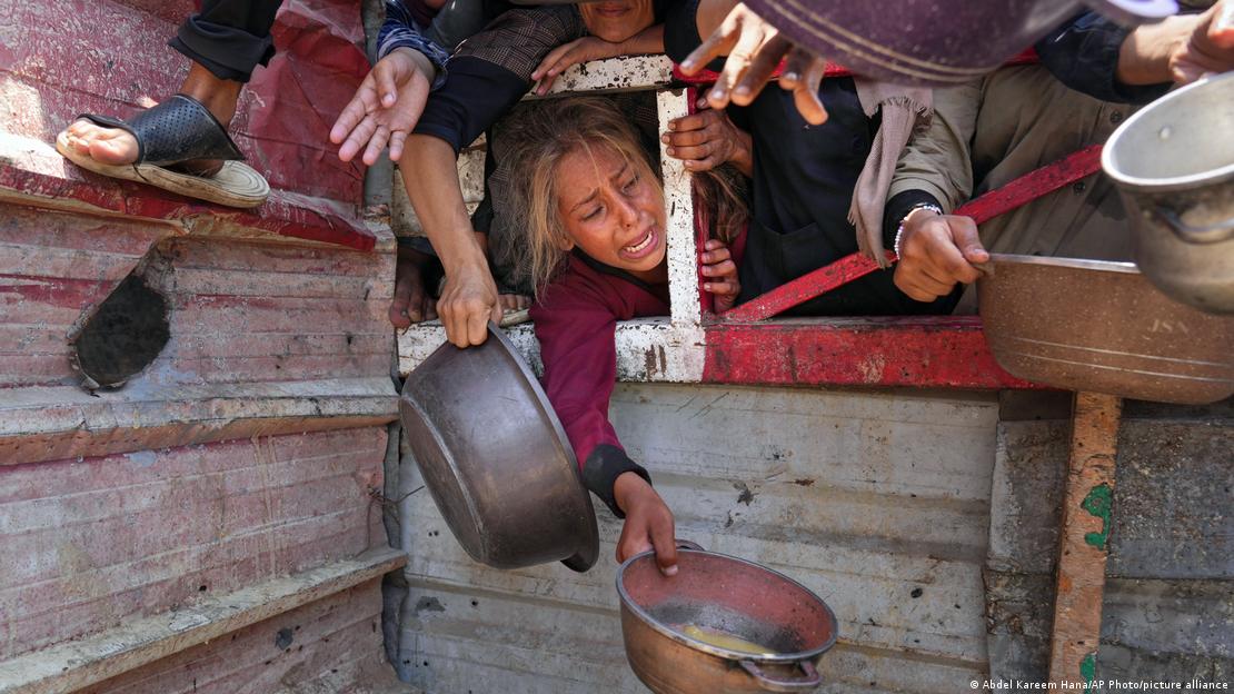 Niños palestinos luchan por conseguir alimentos donados en una cocina comunitaria, en la ciudad de Gaza, al norte del enclave. (Archivo: 26.07.2025)