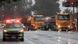 Several trucks and an emergency vehicle standing on a wet road Several trucks and an emergency vehicle standing on a wet road
