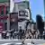 A woman carries an umbrella to shelter from the sun while crossing a street in central Tokyo on July 29, 2025