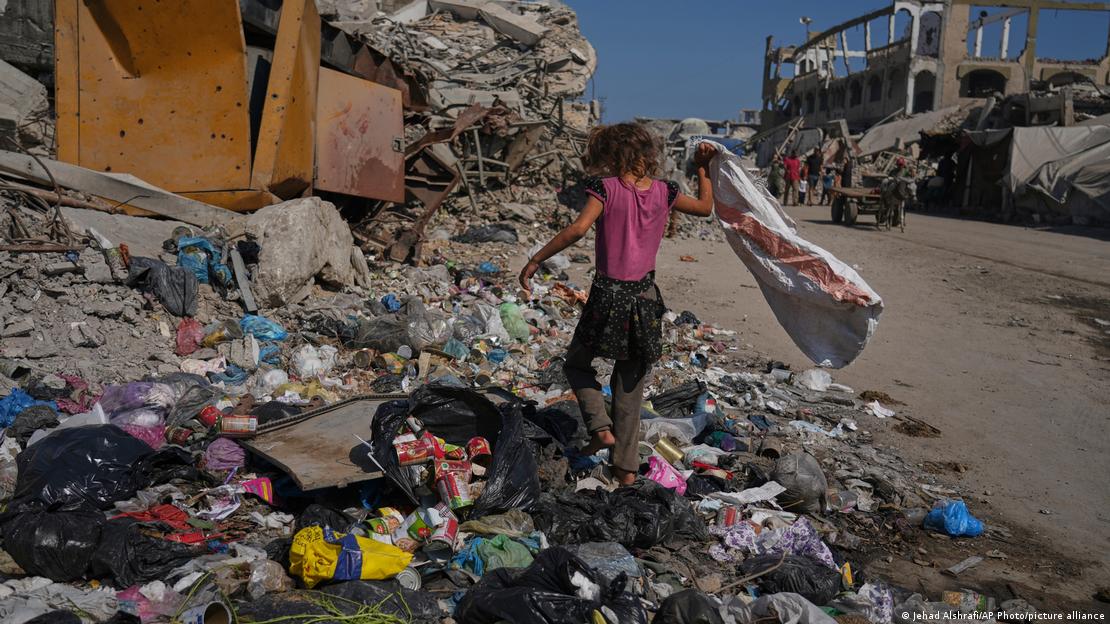 Menina busca plástico para combustível de cozinha perto de um acampamento para deslocados internos em Gaza