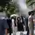 People try to cool off with water sprayed by shops on a hot summer day in Tehran, Iran on July 22, 2025
