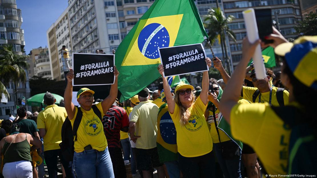 Apoiadores de Bolsonaro levantam cartazes e bandeiras do Brasil
