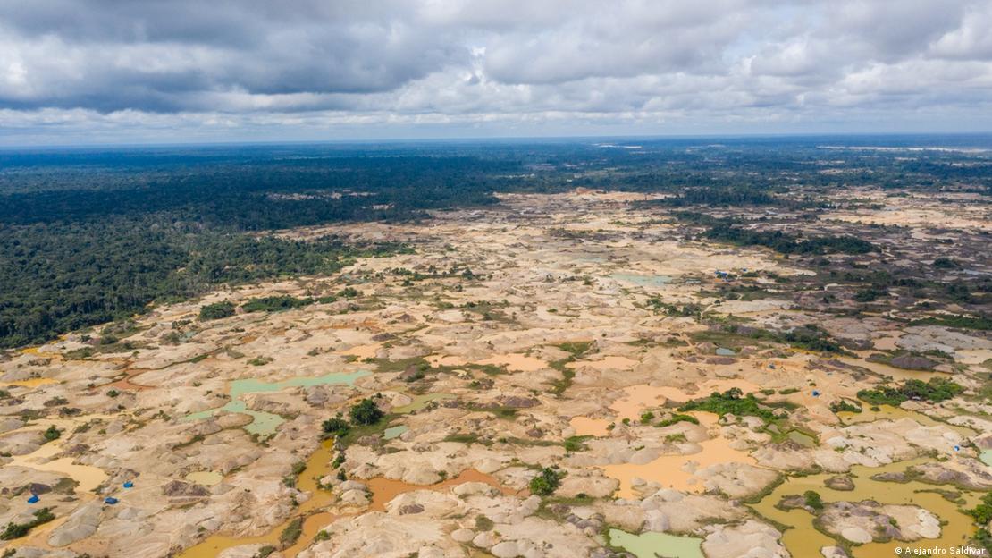 Área na floresta amazônica completamente desmatada pelo garimpo, com poças de água de cor incomum devido ao uso do mercúrio
