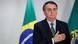 Jair Bolsonaro com a mão sobre o lado esquerdo do peito e em frente à bandeira do Brasil Jair Bolsonaro com a mão sobre o lado esquerdo do peito e em frente à bandeira do Brasil