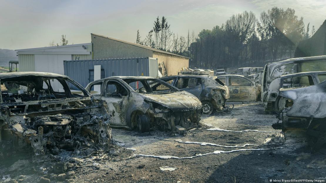 Yan yana dizilmiş, tamamen yanmış çok sayıda aracın, plastik aksamları erimiş ve kül renginde iskeletleri görülüyor. Araçların çevresi küle bulanmış halde