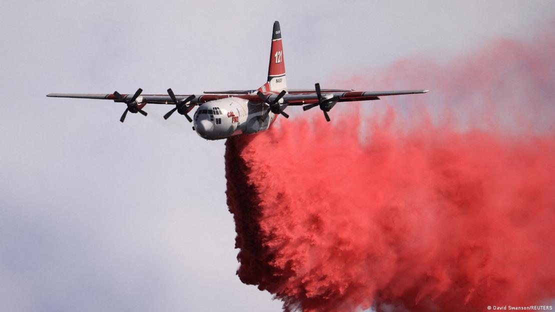 Un avión de extinción de incendios arroja retardante de fuego.