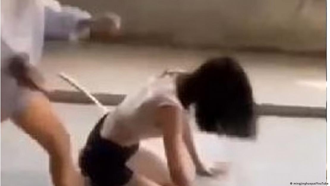 图为受害者（右）被施暴者用脚踹跪在地上