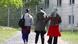 Three refugee women seen from the back, walking towards a fenced-in refugee home in Thuringia Three refugee women seen from the back, walking towards a fenced-in refugee home in Thuringia