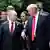 Putin y Trump conversan cominando rodeados de otras personas.