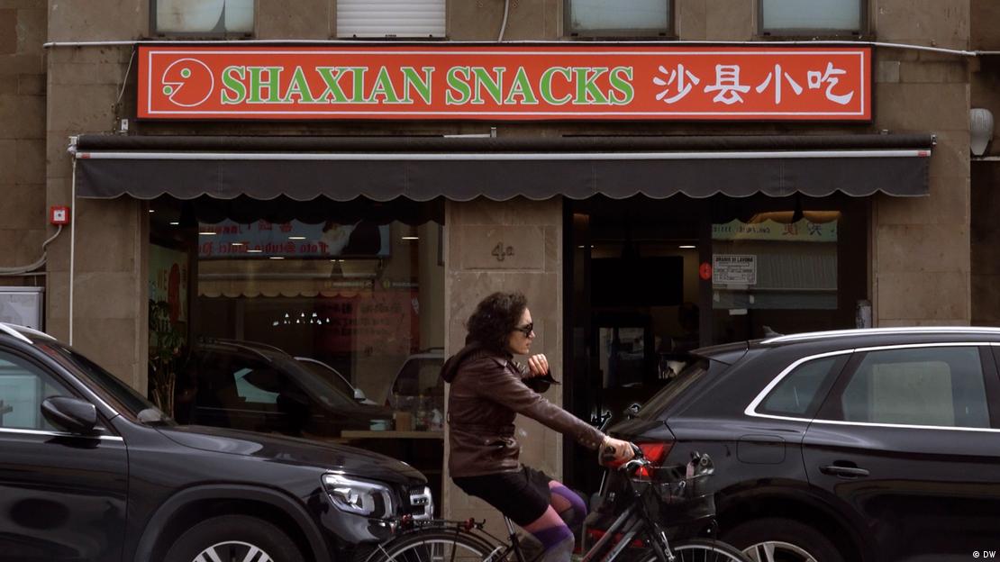 图为一名华人移民骑车驶过普拉托街区一家中式小吃店。 图为一名华人移民骑车驶过普拉托街区一家中式小吃店。