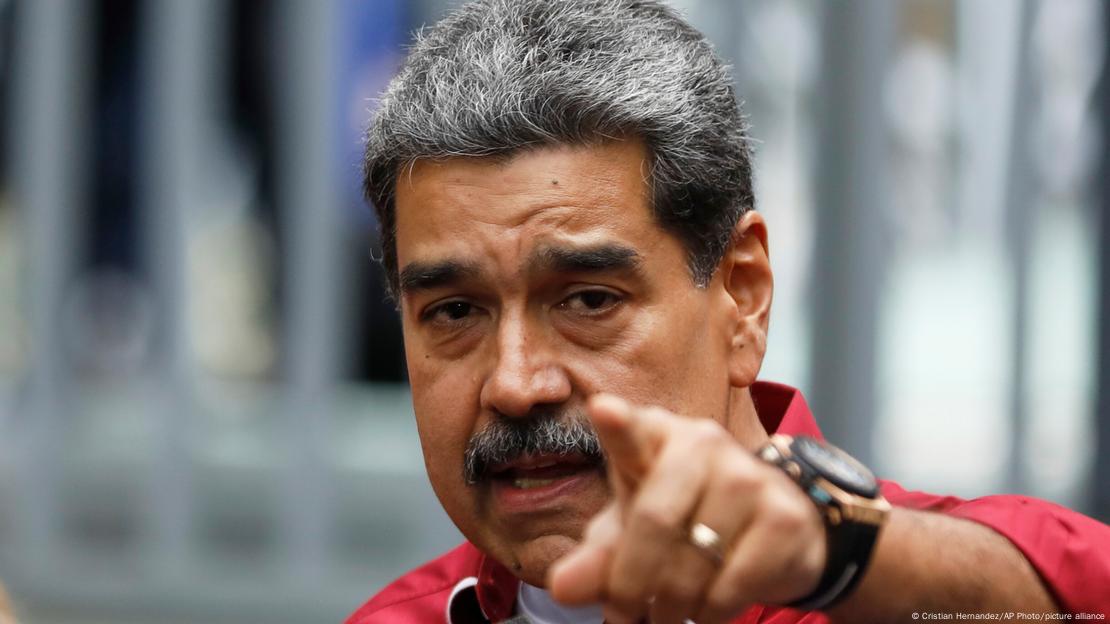 Nicolas Maduro saat takılı sol kolunu ileriye doğru uzatmış, işaret parmağı ile bir şeyi gösteriyor