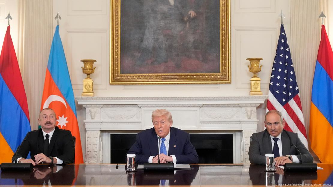 İlham Aliyev, Donald Trump ve Nikol Paşinyan Beyaz Saray'da bir masanın gerisinde yan yana oturuyorlar. Liderlerin arkasında ülkelerinin bayrakları yer alıyor