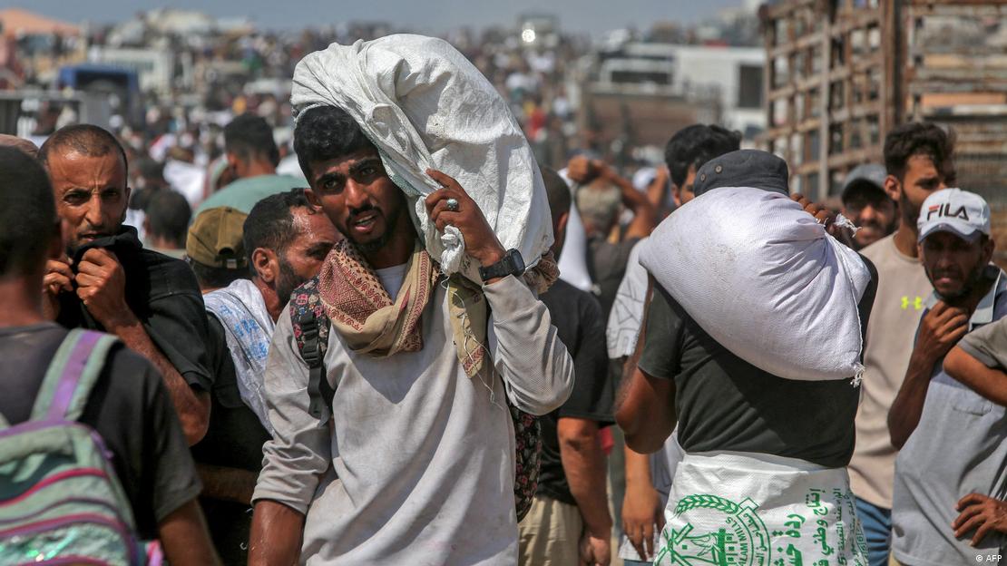 Palestinos cargan comida tras asaltar un camión con ayuda humanitaria ayer en Jan Yunis, al sur de la Franja de Gaza.