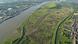 Aerial picture of the a river, with industrial buildings on one shore and green polders and waterways on the other shore. Polders near Kruibeke, Belgium Aerial picture of the a river, with industrial buildings on one shore and green polders and waterways on the other shore. Polders near Kruibeke, Belgium