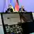 Se ve a Zelensky y Merz sentados detrás de unos micrófonos al fondo. En primer plano, una pantalla de ordenador muestra una videollamada con varios participantes.