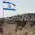 An Israeli flag flying with the Maale Adumim settlement in the background