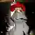 A model wearing a huge red hat on the runway of the Comme des Garcons Autumn/Winter 2025 fashion show in Paris