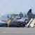 Am Flughafen Leipzig/Halle steht ein Flugzeug der Qatar Airways auf dem Rollfeld, davor etliche schwarze Vans
