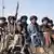 Muyahidines fuertemente armados sentados en la parte trasera de una camioneta durante el desfile para celebrar el tercer aniversario de la toma del poder por los talibanes en Kandahar, el 14 de agosto del año pasado.