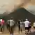 People watch a wildfire burning in Castrillo de Cabrera, northwestern Spain, on August 16, 2025.