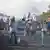 Demonstranten stehen als Blockade auf der Hauptverkehrsstraße zwischen Jerusalem und Tel Aviv, halten israelische Fahnen hoch sprechen durch Megafone
