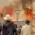 Personas observan un voraz incendio en Veiga das Meas, en el noroeste de España.