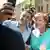 Deutschland Berlin 2015 | Ein Flüchtling macht ein Selfie mit Angela Merkel umringt von weiteren Personen