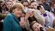 Almanya Başkanı Merkel, etrafında çok sayıda çocukla selfie yaparken, yeşil ceketli Merkel kameralara tebessüm ediyor Almanya Başkanı Merkel, etrafında çok sayıda çocukla selfie yaparken, yeşil ceketli Merkel kameralara tebessüm ediyor