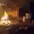 Fuego junto a edificio con destrozos.