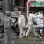 People wearing white personal protective suits carry the body of a victim to a waiting van in Cali, Colombia, on August 21 2025.