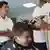 A youth gets his hair cut at a barbershop to adhere to public school rules for hair