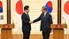 Lee Jae Myung and Shigeru Ishiba shake hands for the press in front of South Korean and Japanese flags Lee Jae Myung and Shigeru Ishiba shake hands for the press in front of South Korean and Japanese flags