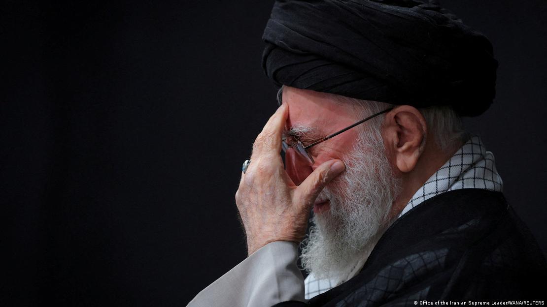 İran'ın dini lideri Ali Hamaney sol eliyle yüzünü tutarken. 