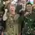 US Indo-Pacific Command Admiral Samuel Paparo, Deputy Commander of the Indonesian Armed Forces General Tandyo Budi Revita, and Canada's Chief of the Defence Staff General Jennie Carignan all smile and have their rights fists raised towards the camera