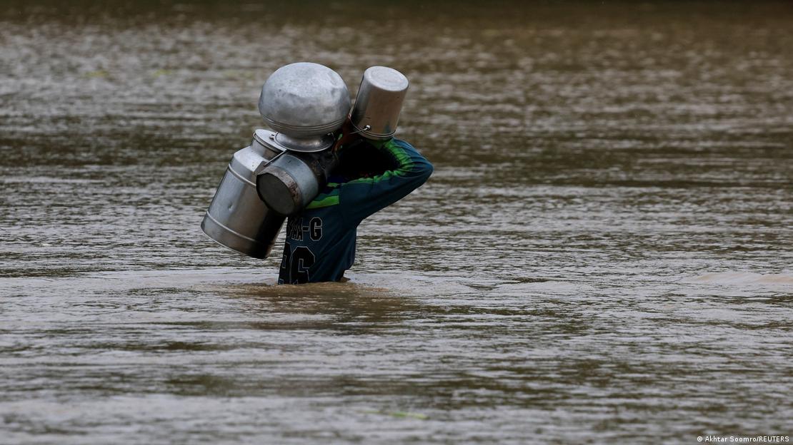 قصور میں پانی کی سطح اتنی بلند ہے کہ ایک شخص سینے تک ڈوبا ہوا ہے اور اس نے سر پر اپنے برتن اُٹھا رکھے ہیں