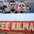 Kilmar Ábrego García y su mujer, gente atrás. En primer plano, un cartel que reza: "Free Kilmar"