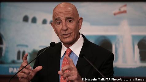 ABD'nin Türkiye Büyükelçisi Tom Barrack, bir basın toplantısında konuşurken iki elini havaya kaldırıyor 