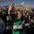 A Syrian woman takes a selfie, holding the new Syrian flag