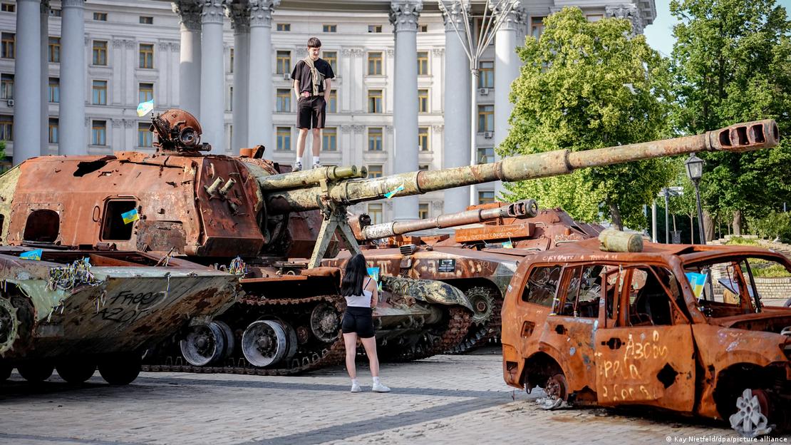 Ein junges Paar bei einer Ausstellung ausgebrannter russischer Panzer und Fahrzeuge im Zentrum von Kyjiw
