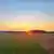 Sonnenuntergang, im Vordergrund eine Sommerwiese